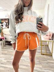Orange Windbreaker shorts with white contrast stripe